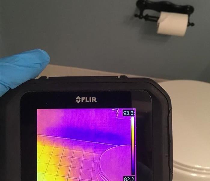 Using a moisture meter to measure the moisture in a bathroom in Delray Beach.